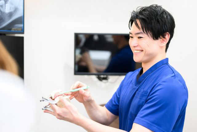 歯科予防の説明をしている院長